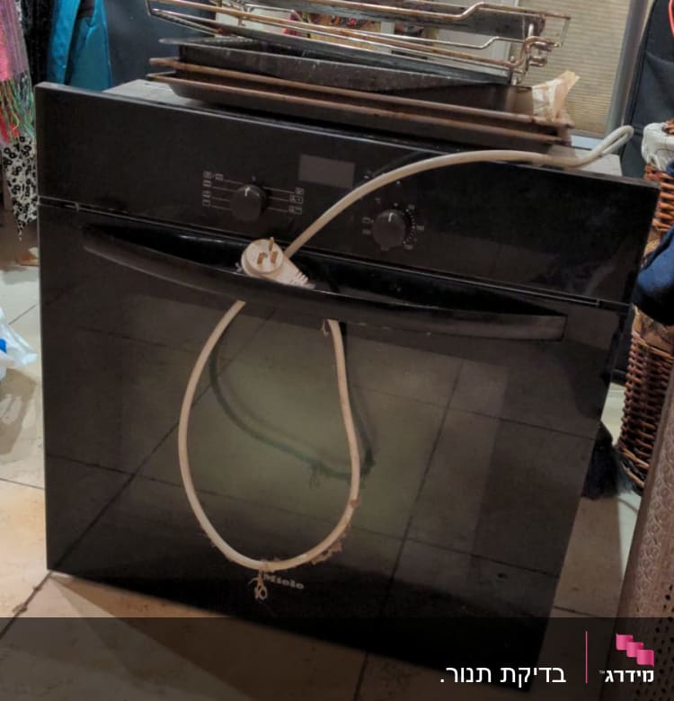 תנור חשמלי שחור עם כבל חשמל לבן